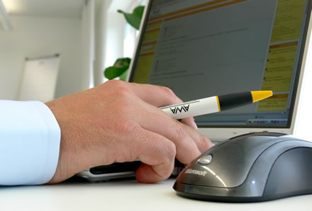 Hand, Kugelschreiber, Maus und PC-Bildschirm